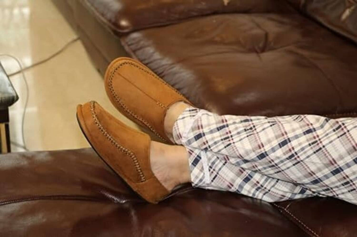 Tan suede moccasin-style slip-on slippers with stitched trim and cushioned insole