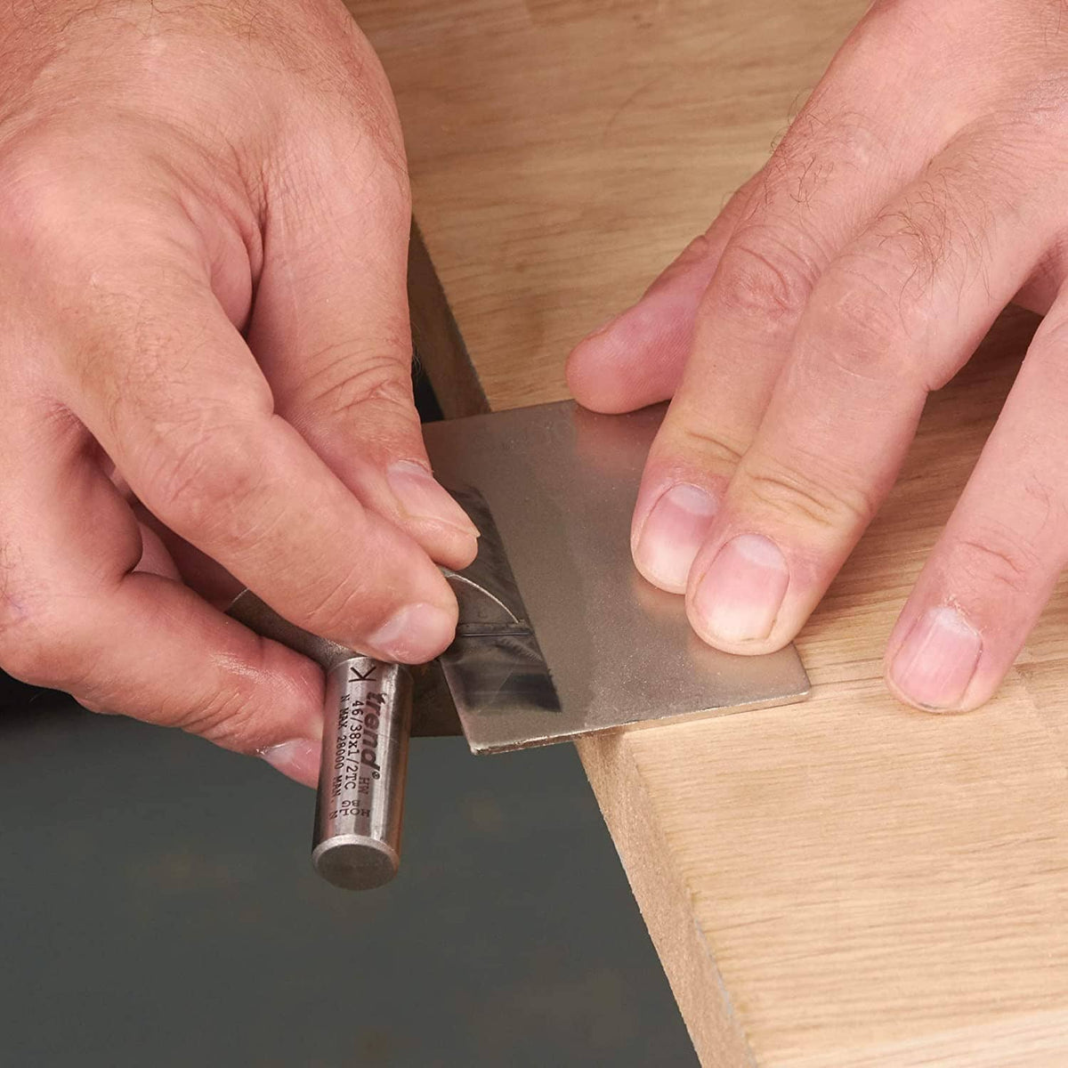 Hands spreading abrasive lapping fluid from a small tube onto a metal plate