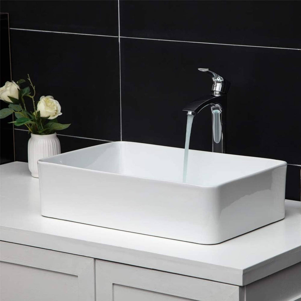 White rectangular vessel sink with chrome faucet and drain hole, glossy ceramic basin
