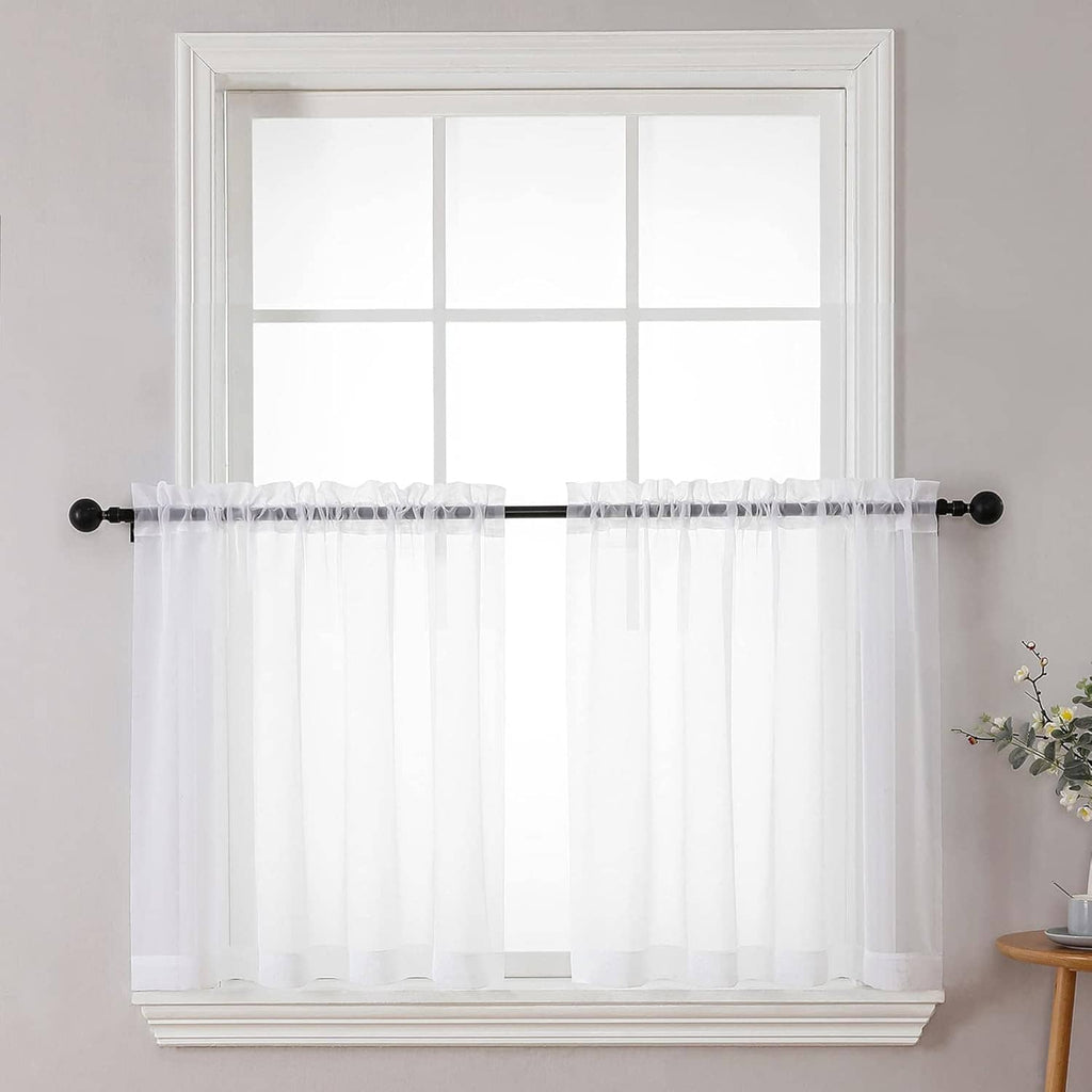 Sheer white curtain panels with gathered top, hanging on a rod