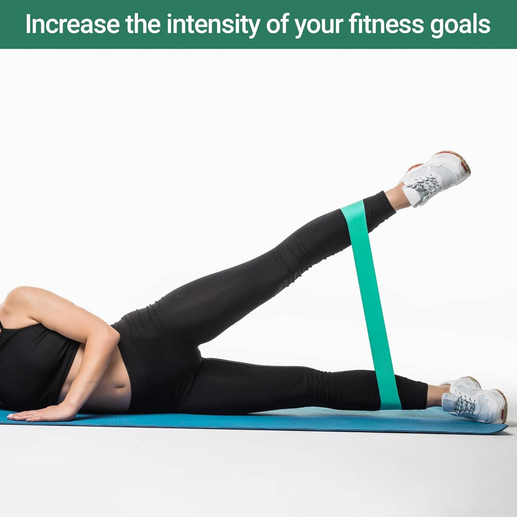 Green resistance loop band used for leg stretch on a mat