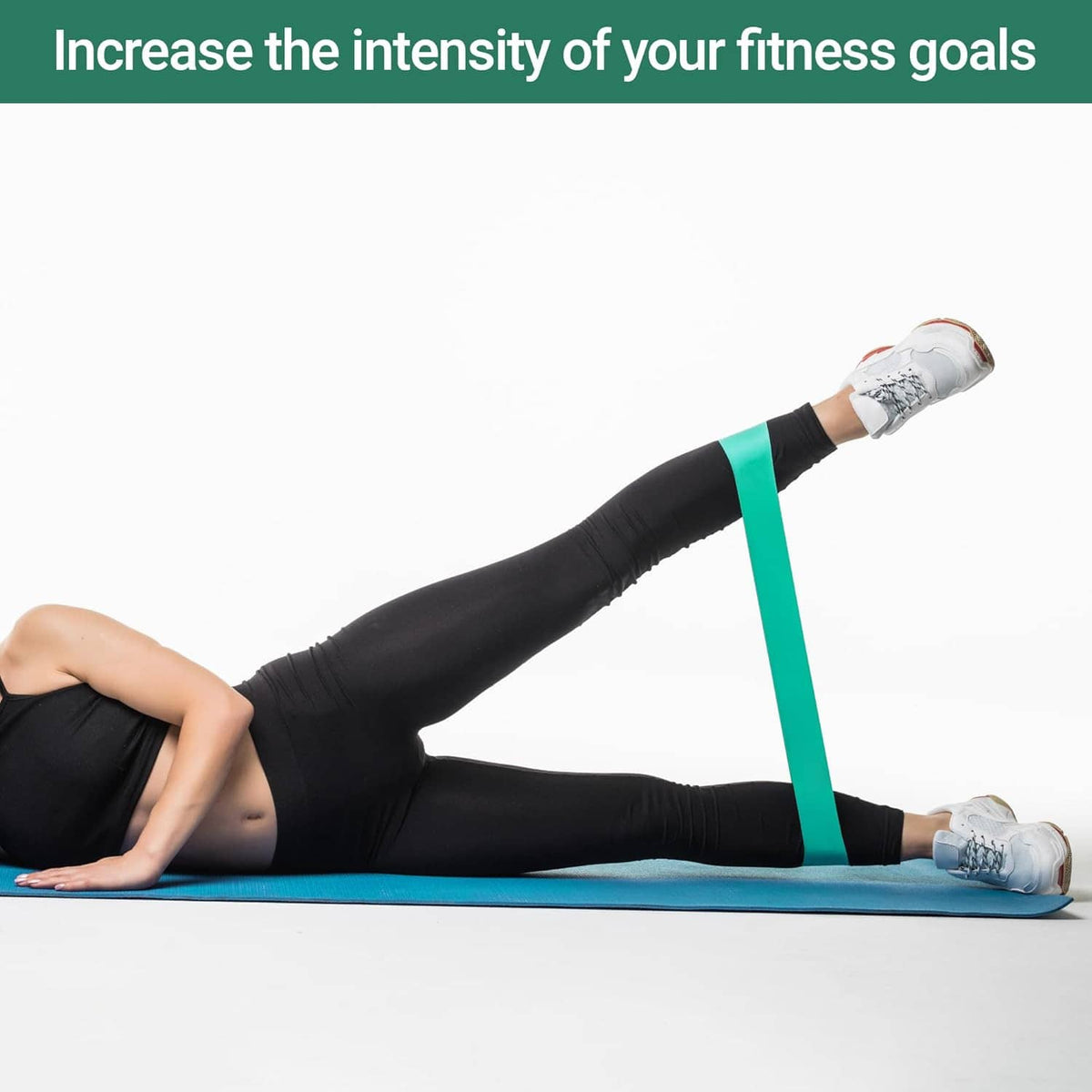 Green resistance loop band used for leg stretch on a mat