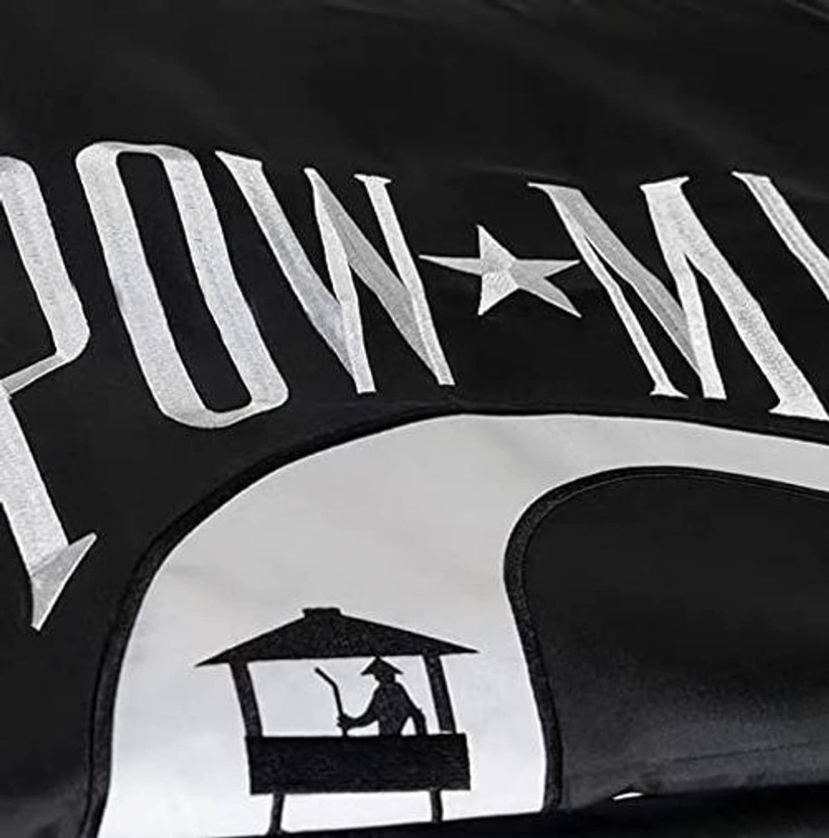 Black flag close-up with 'POW*MIA' stitched letters and star