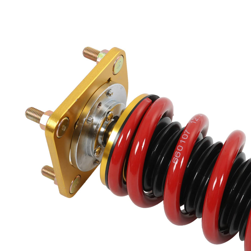 Coilover strut with red spring over black damper and gold mounting plate