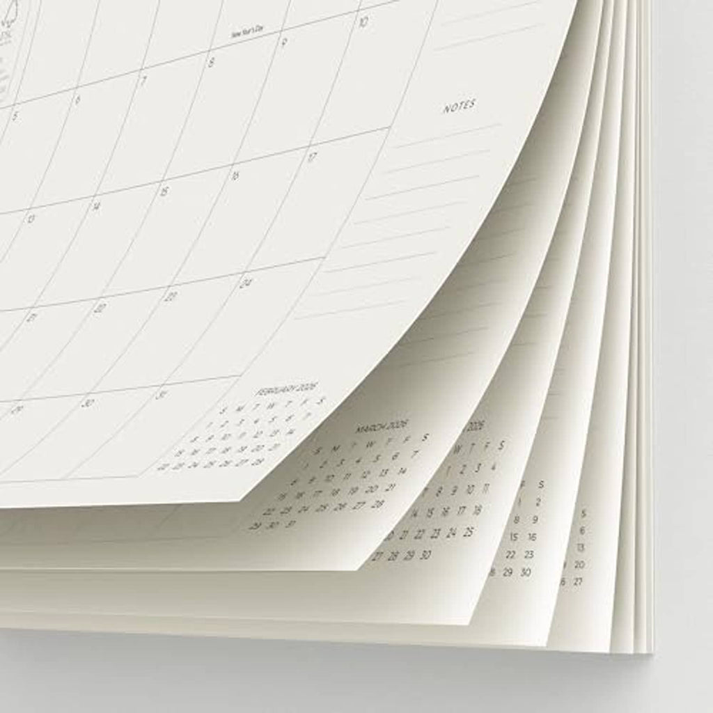 Refrigerator magnetic calendar pages fanned out, showing month grids and notes