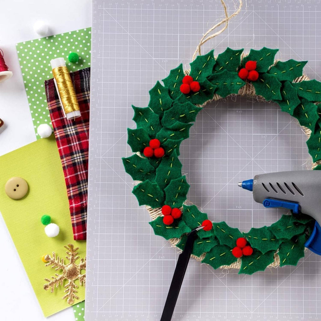 Handmade green felt wreath with red pom pom accents and stitched leaves