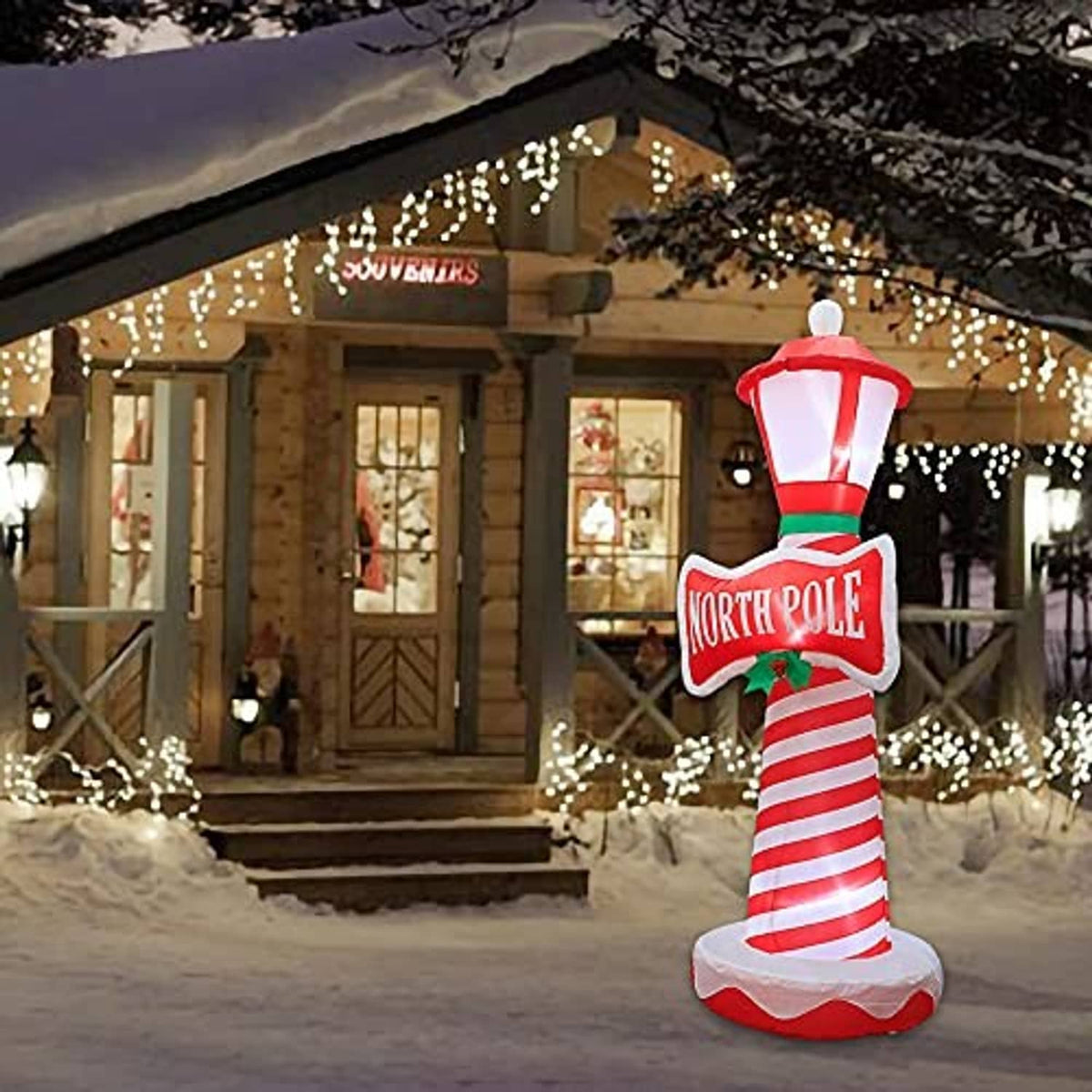 Inflatable lighthouse decoration outdoors with illuminated lantern and striped candy-cane body