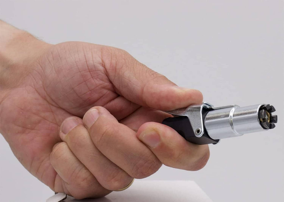 Hand gripping a tire air chuck connector for a secure Schrader valve fit
