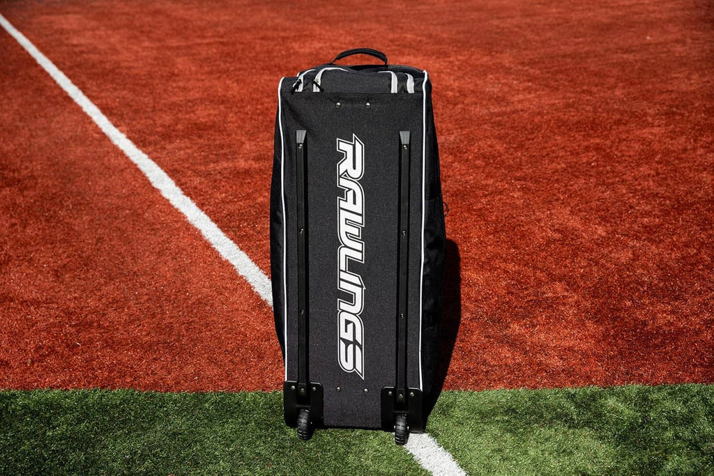 Rear view of black wheeled catcher’s bag with vertical Rawlings logo and wheels
