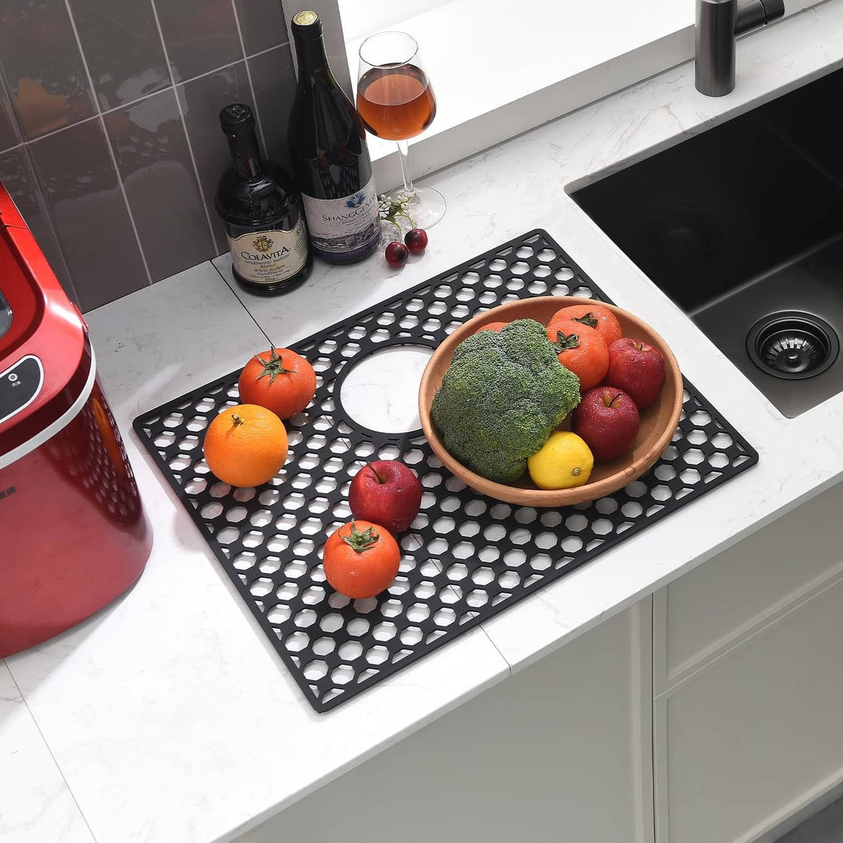 Black perforated sink mat protecting the sink basin with hexagonal hole pattern