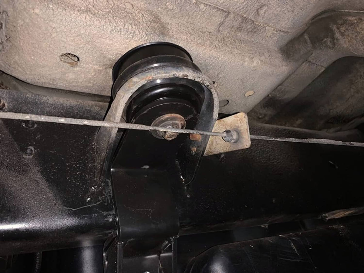 Black body mount bushing with red ring and center mounting stud, underside view