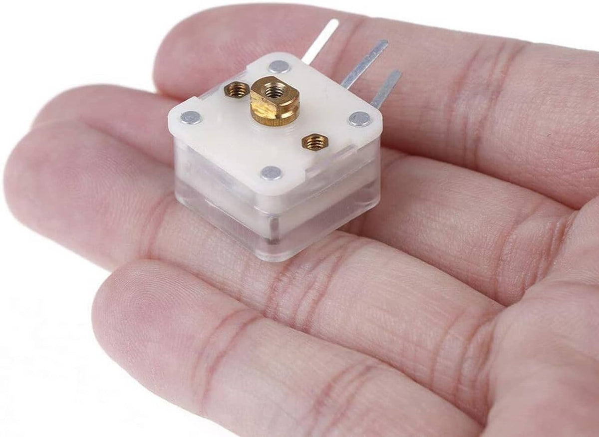 Duplex radio variable capacitor held in hand, showing gold terminals on white housing