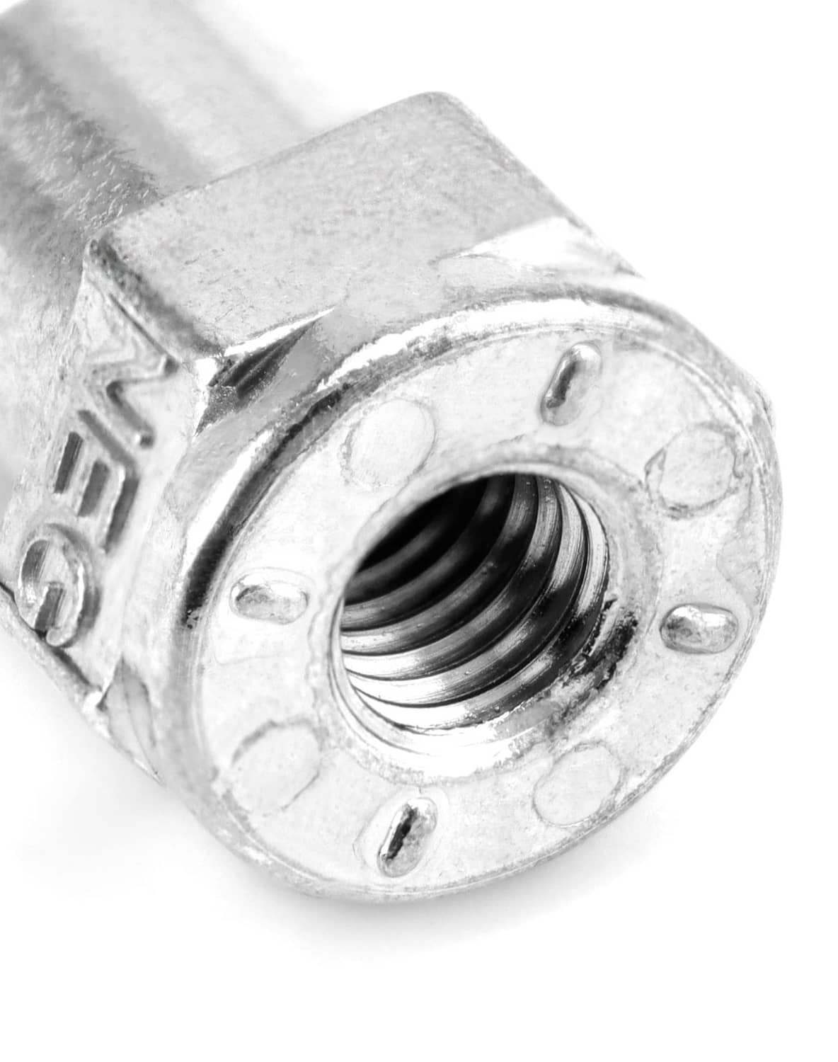 Close-up of zinc alloy battery terminal opening with threaded insert and markings.