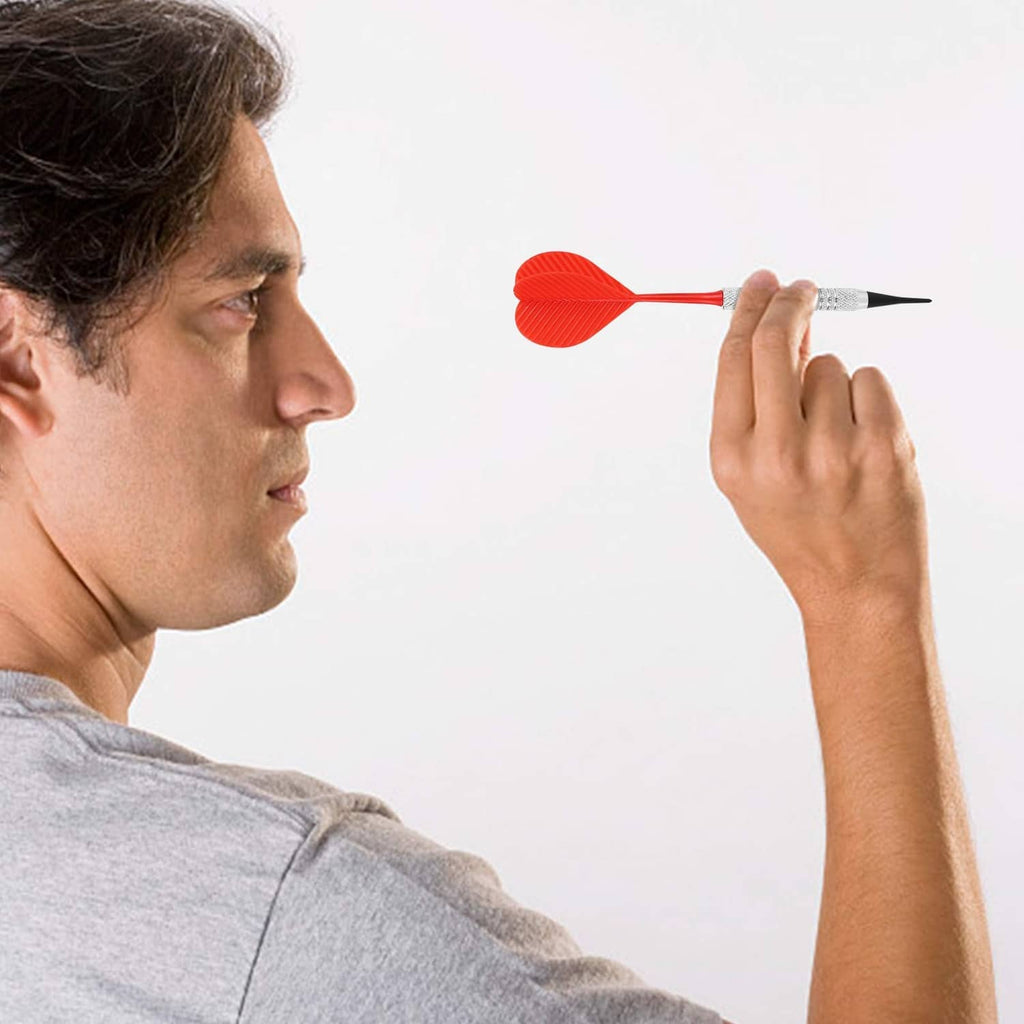 Red soft tip dart held by a person with textured silver barrel and orange flight