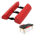 Red massage table arm rest bolsters with black securing straps, padded PU leather