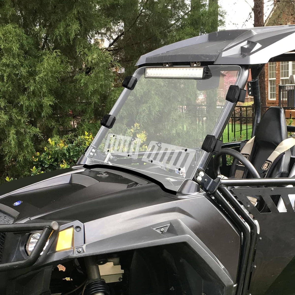 Clear vented windshield mounted on an off-road UTV with black brackets