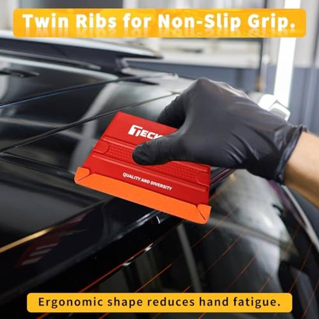 Red trapezoid felt squeegee for vinyl wrap held by black-gloved hand on car glass.