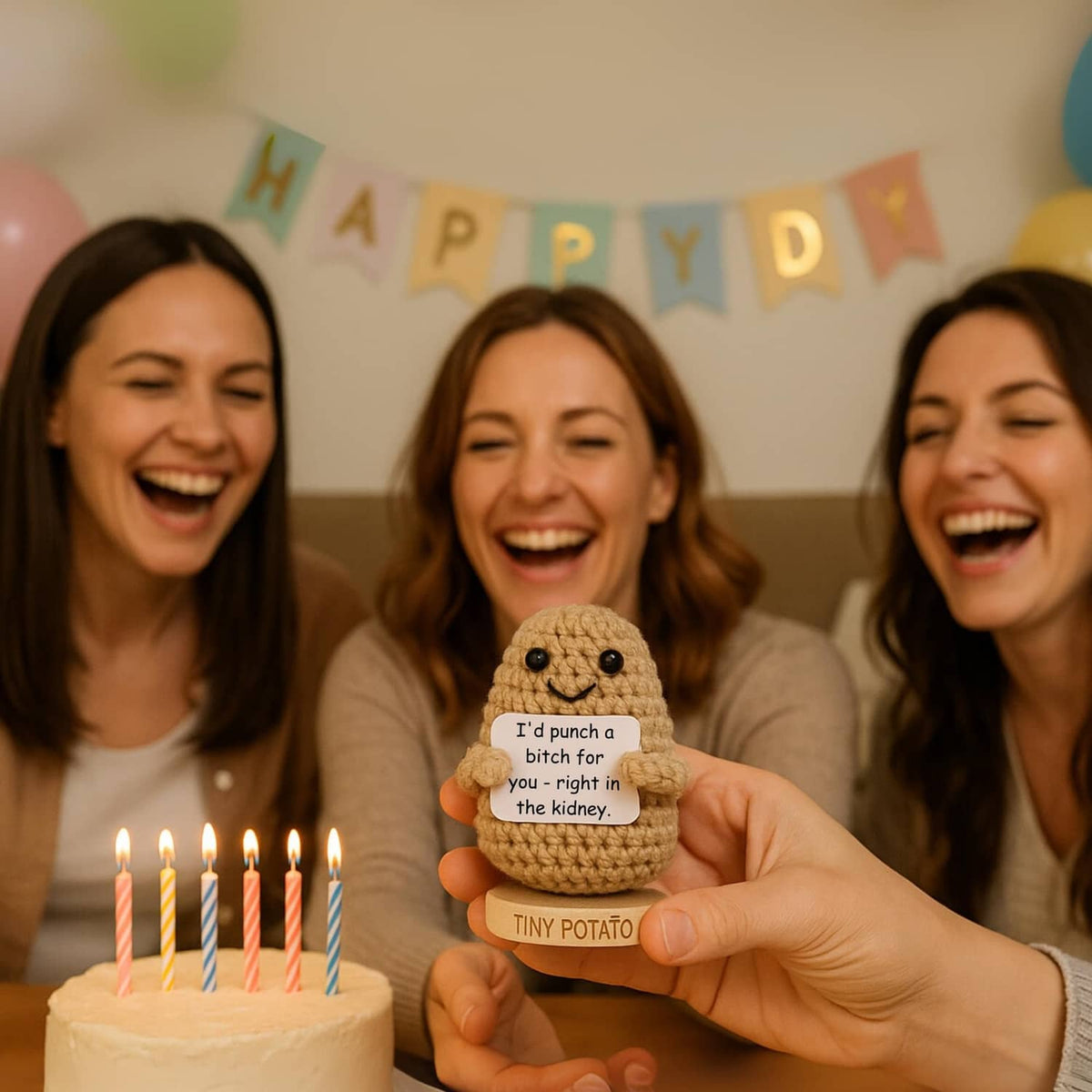 Small crochet potato figurine held up near birthday cake candles, smiling face