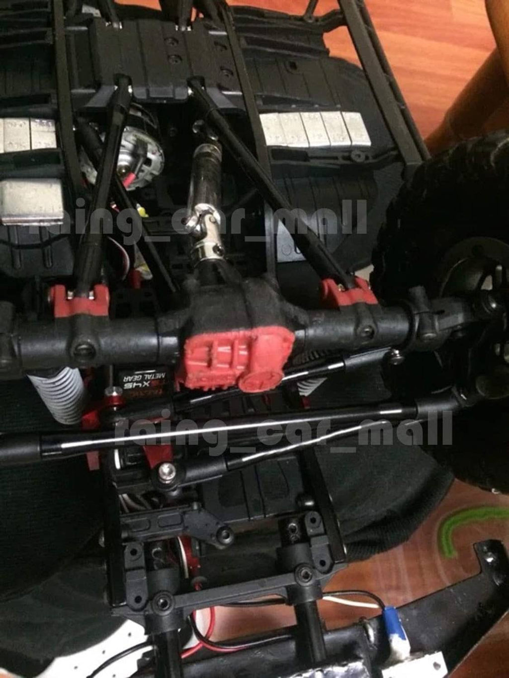 Black rod linkages on an RC truck chassis, angled view of mounted bars