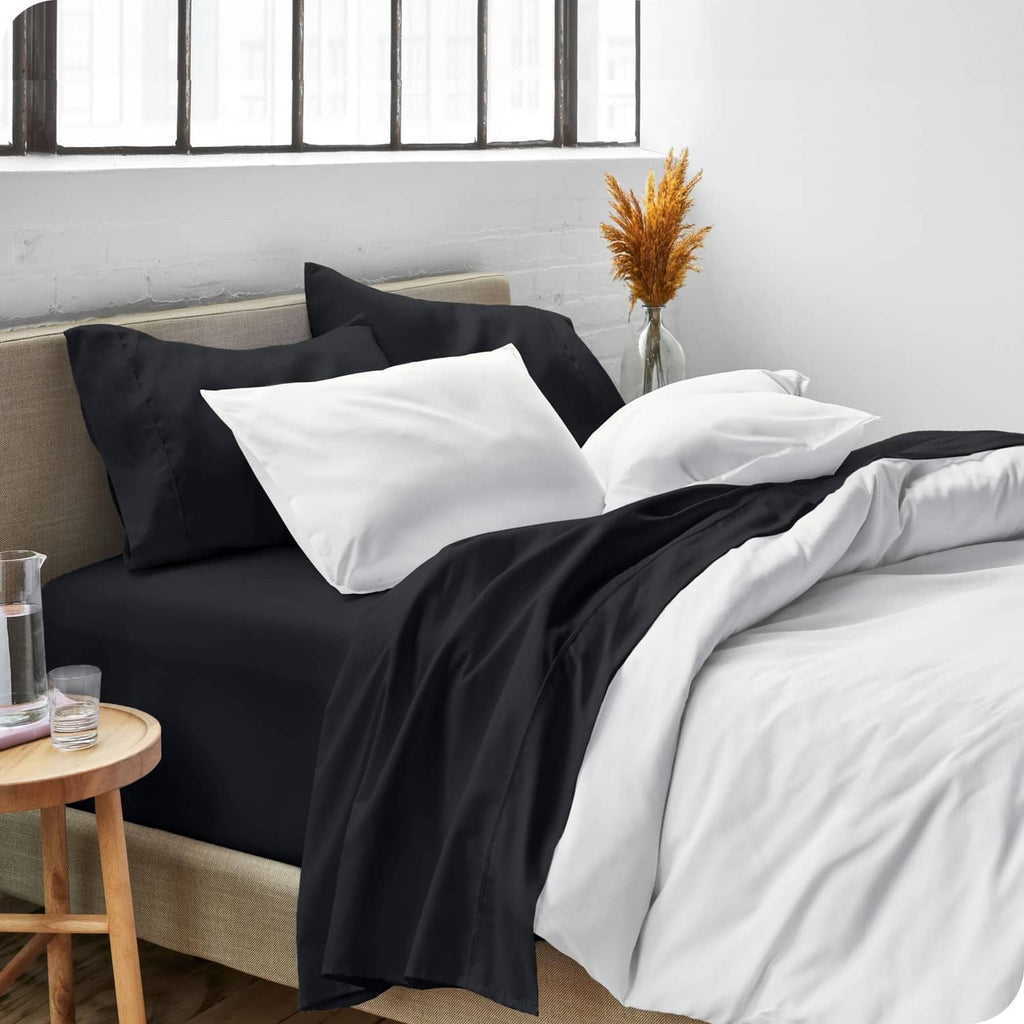 Black and white bed sheet set with two pillowcases on neutral sofa