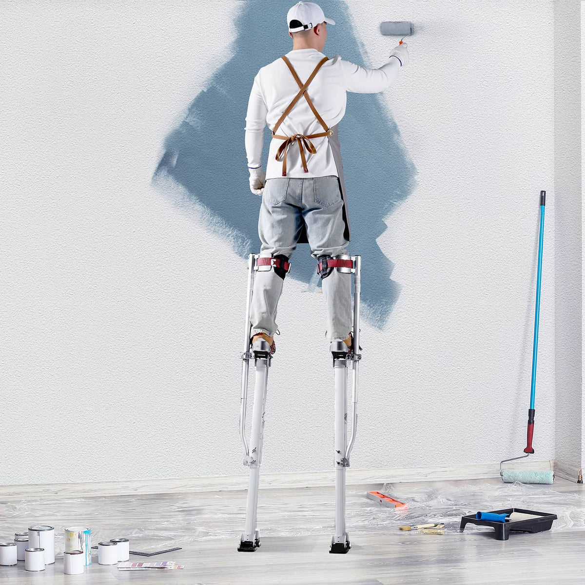 Painter standing on adjustable drywall stilts with knee pads and rubber feet