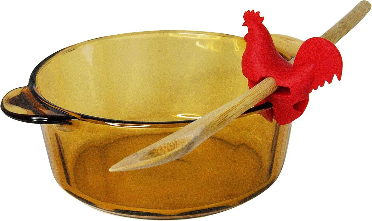 Red rooster spoon holder and wooden spoon resting on amber pot rim