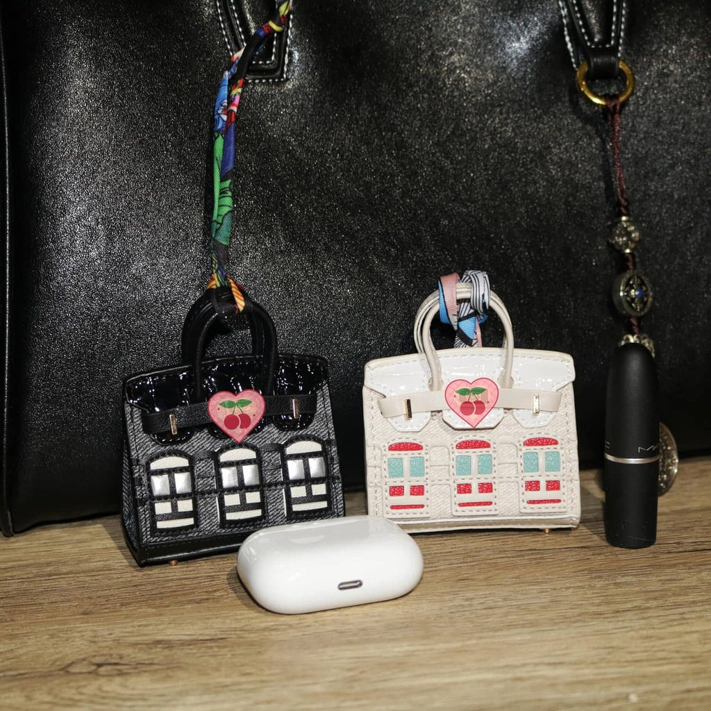 Black and white mini backpack keychain pouches with heart charms and window prints.