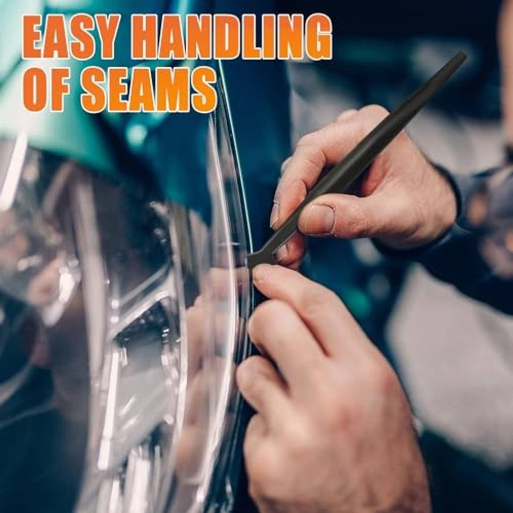 Hand smoothing window film on glass with a black trim/seam tool