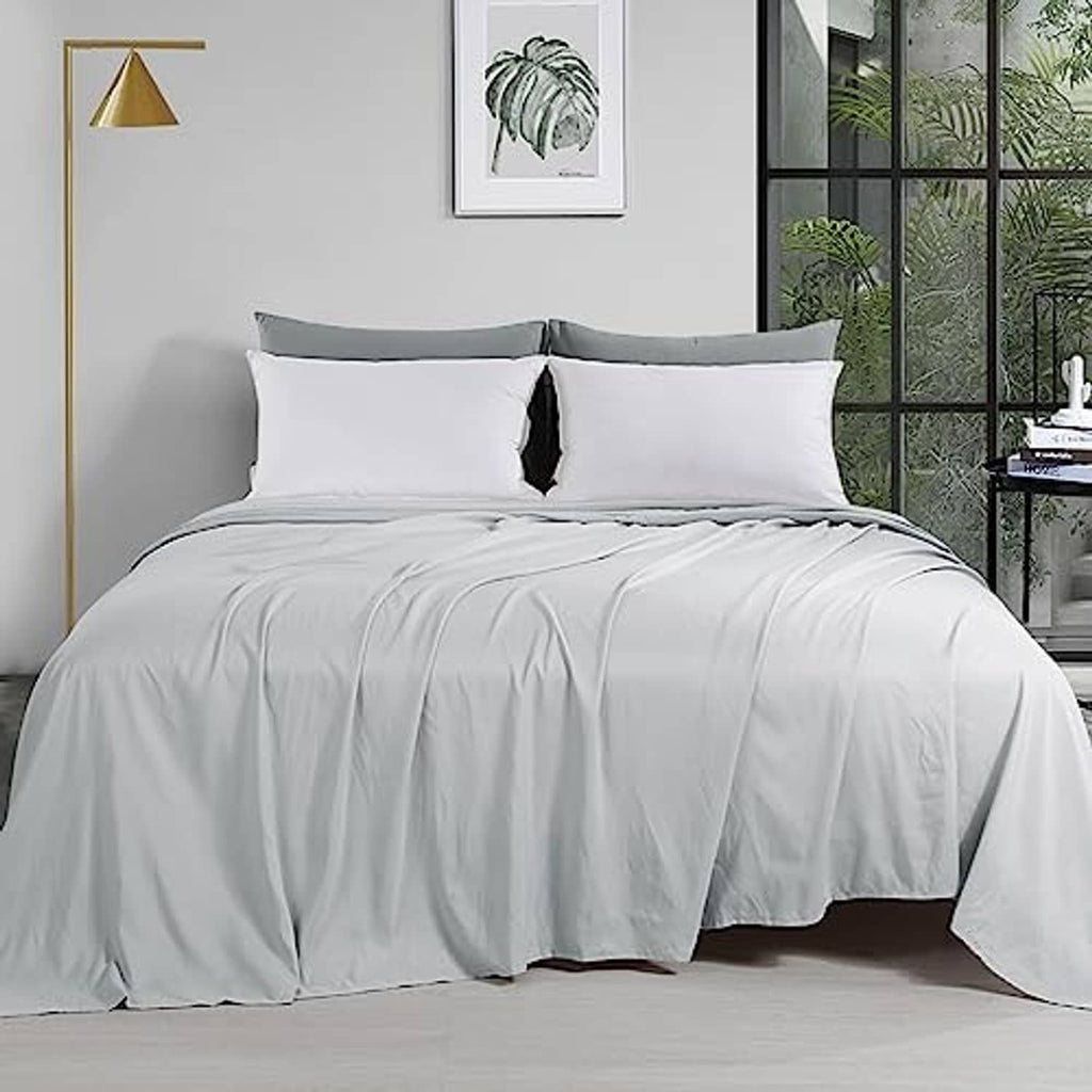 Light grey oversized king flat sheet on bed, neatly draped and smooth
