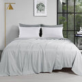 Light grey oversized king flat sheet on bed, neatly draped and smooth