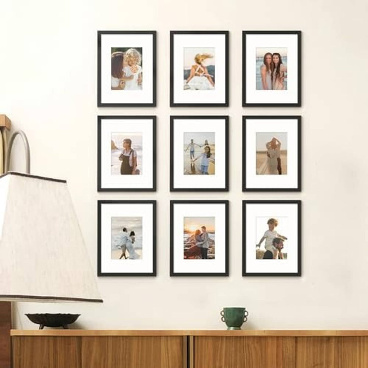 Black photo frame set with white mats arranged in a 3x3 grid on a wall