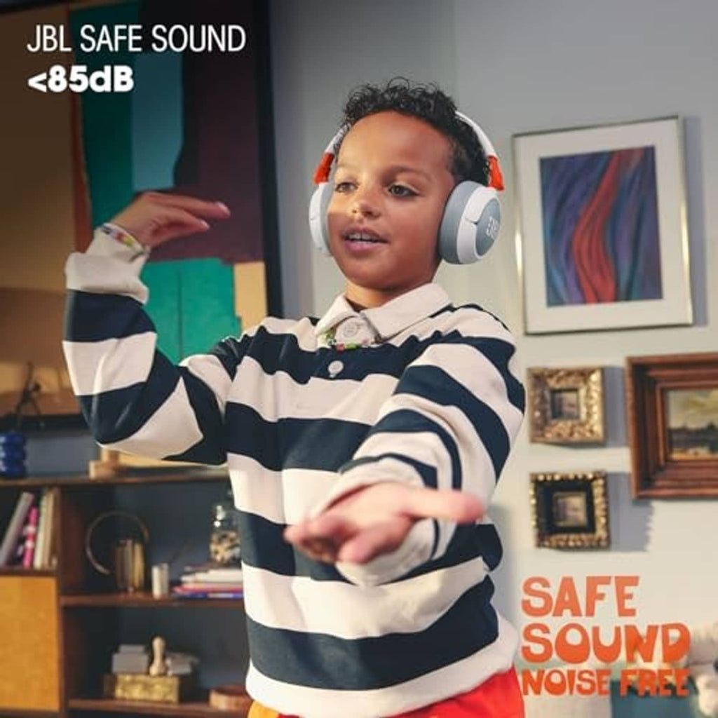 Child wearing white and gray over-ear JBL headphones with orange details.