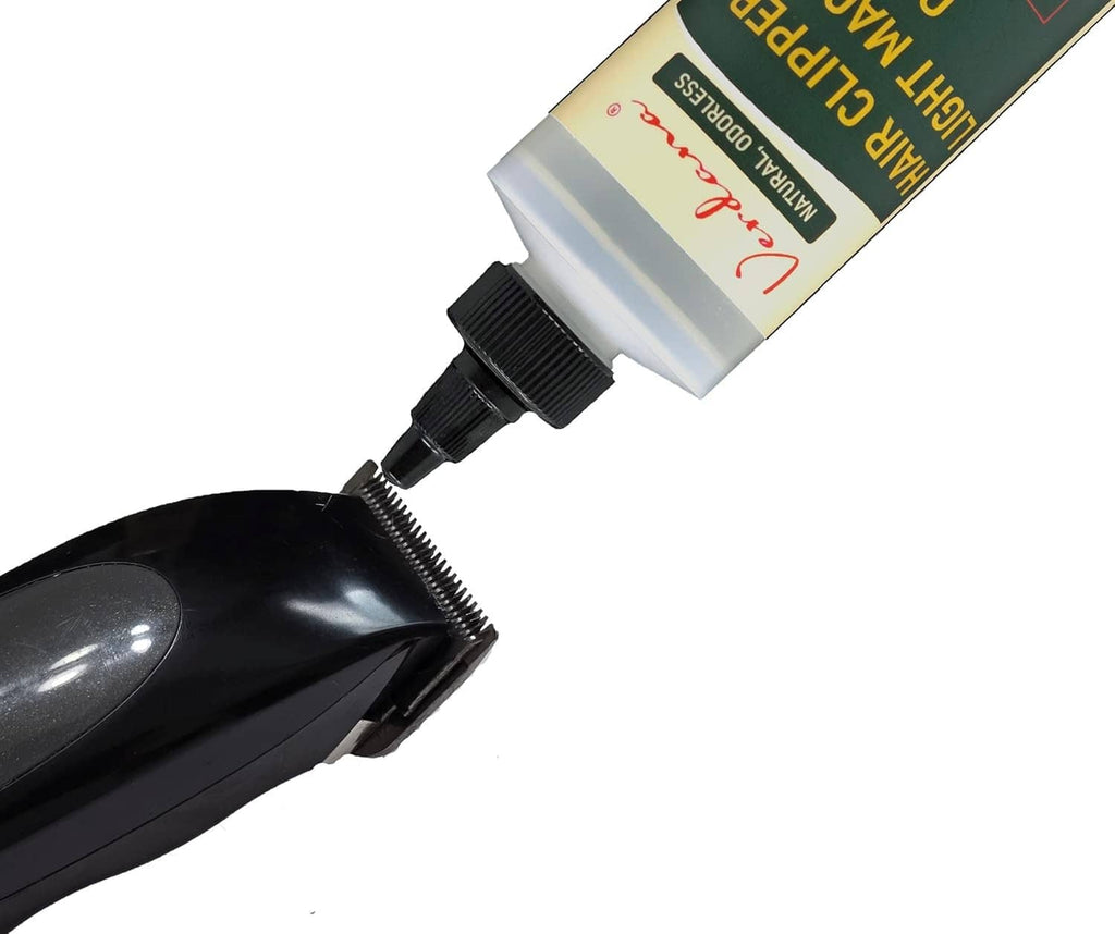 Hair clipper oil squeeze bottle with black pointed nozzle and bottle neck