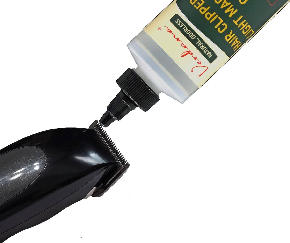 Hair clipper oil squeeze bottle with black pointed nozzle and bottle neck