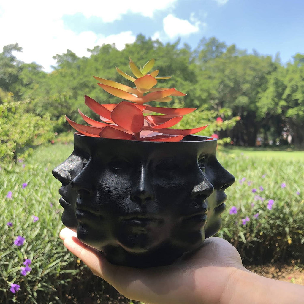 Black multi-face succulent planter with orange-red and green faux leaves.