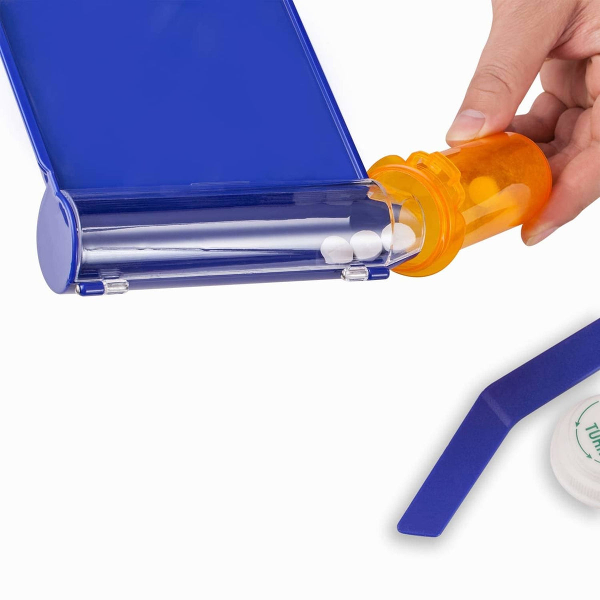 Blue pill tray with spatula pouring white tablets from orange bottle