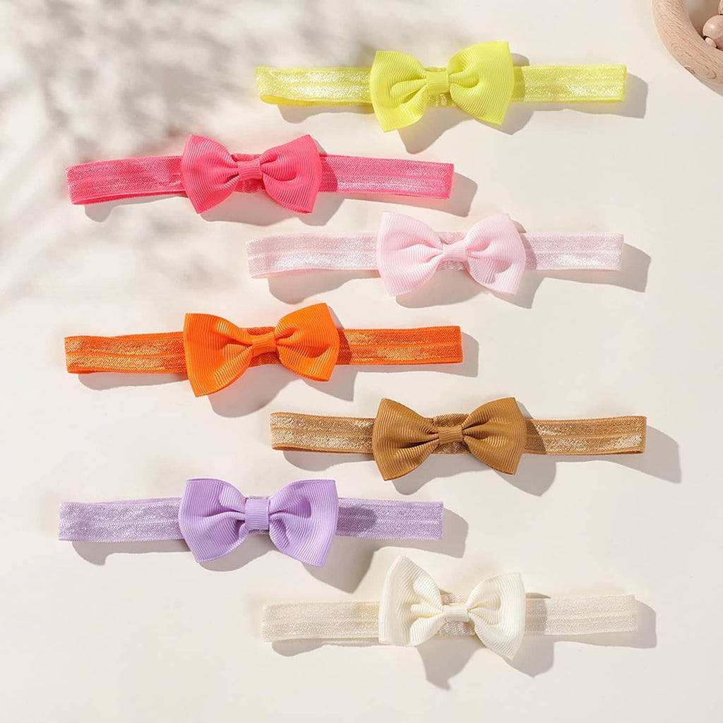 Assorted baby headbands with pastel bows, glittery bands, flat lay