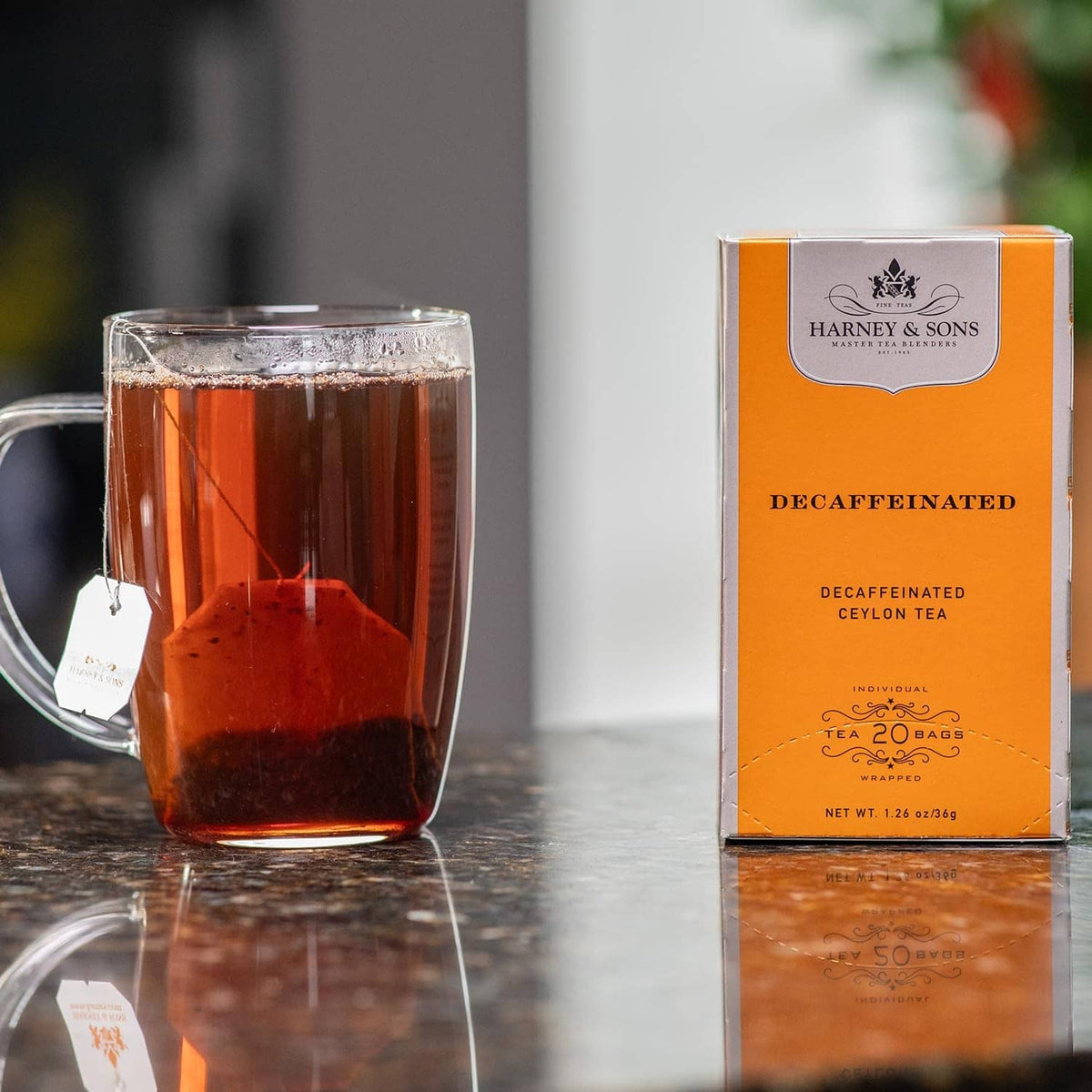 Decaffeinated Ceylon tea box beside clear mug filled with dark tea