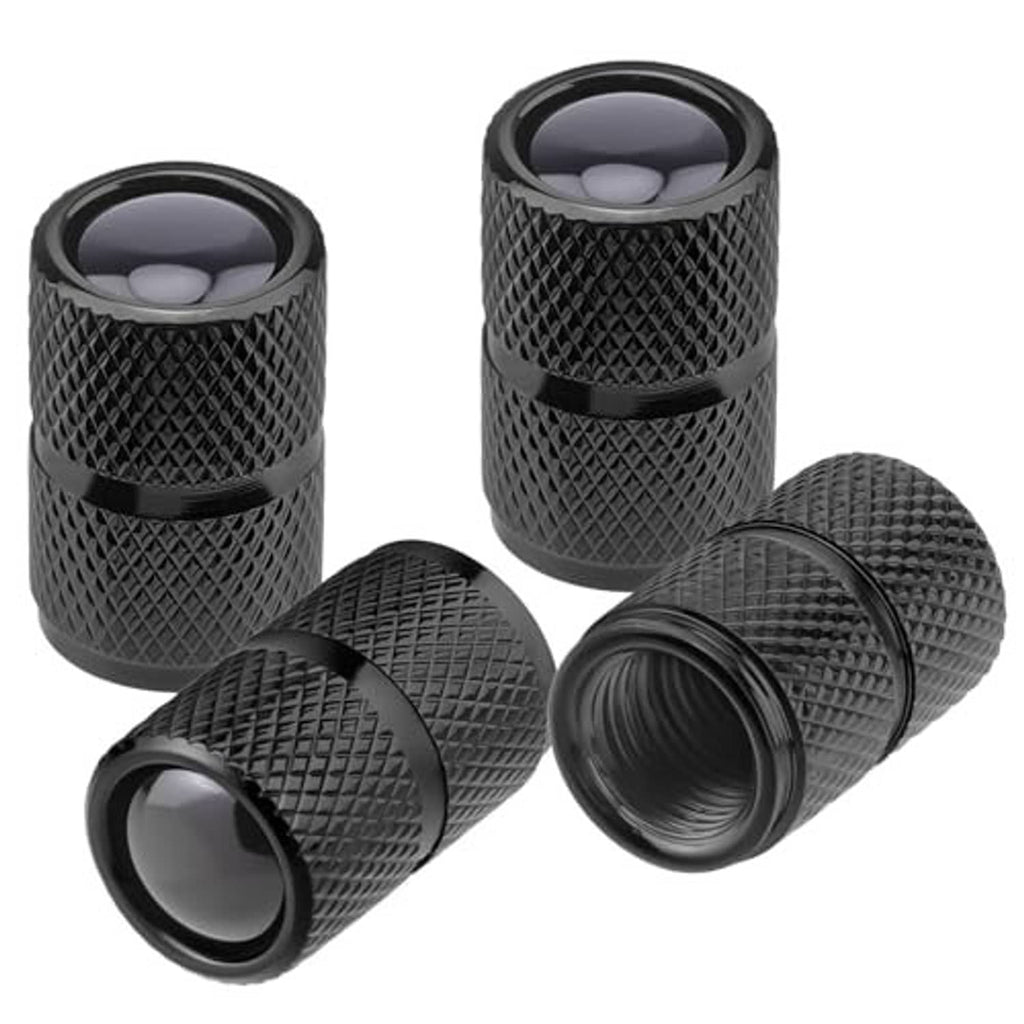 Four black aluminum tire valve stem caps with textured sides and protective end covers