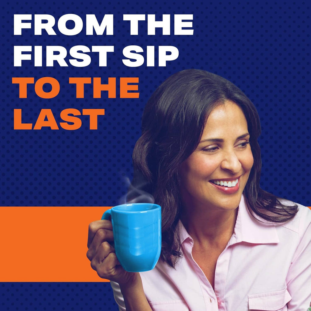 Decaf ground coffee mug held by a smiling person, blue cup in hand.