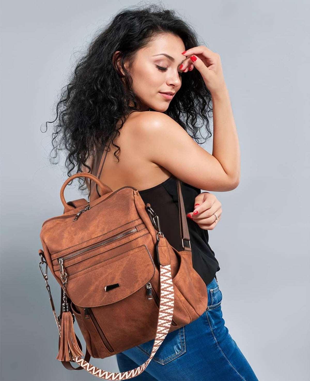 Brown PU leather backpack purse with front flap, zippers, and tassel accents