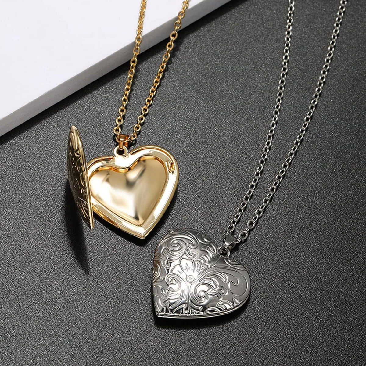 Two heart photo lockets, gold and silver engraved scrollwork, on separate link chains
