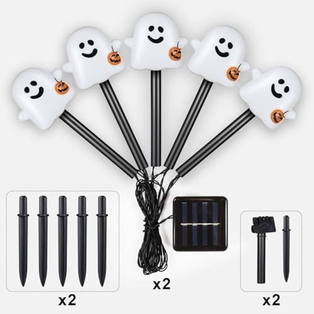 White smiling ghost solar pathway lights on stakes, with solar panel and bundled wire
