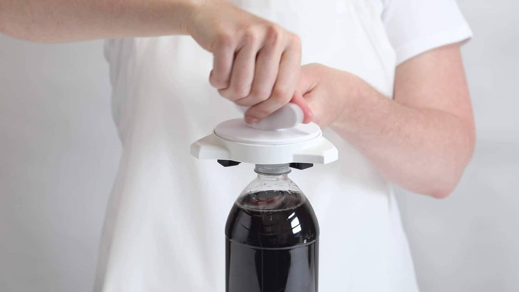 White jar and bottle opener placed on a bottle cap with hand grip