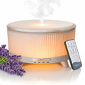 White aromatherapy diffuser with lid mist stream and glowing control panel, three-foot base
