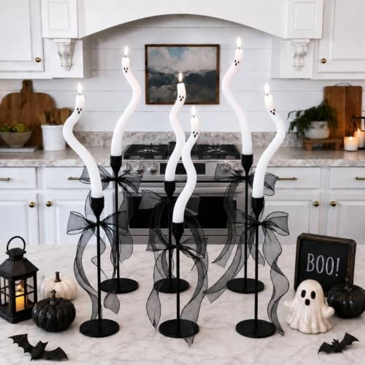 Twisting white ghost candles on black stand bases with sheer black bow accents
