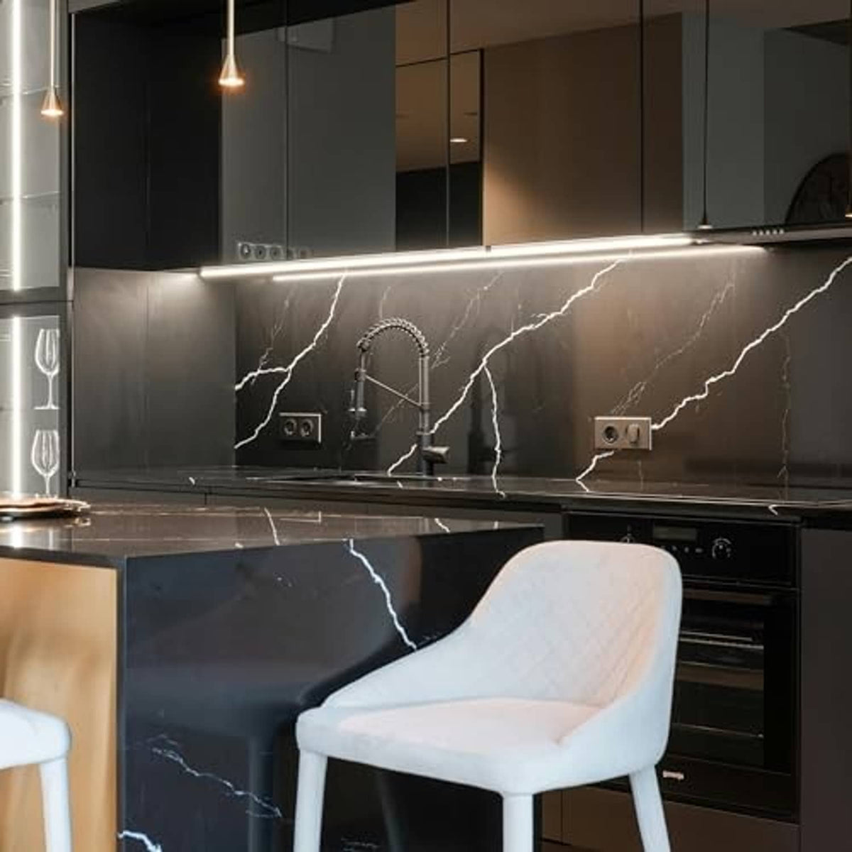 Under-cabinet LED lighting glow in a modern kitchen with dark cabinets