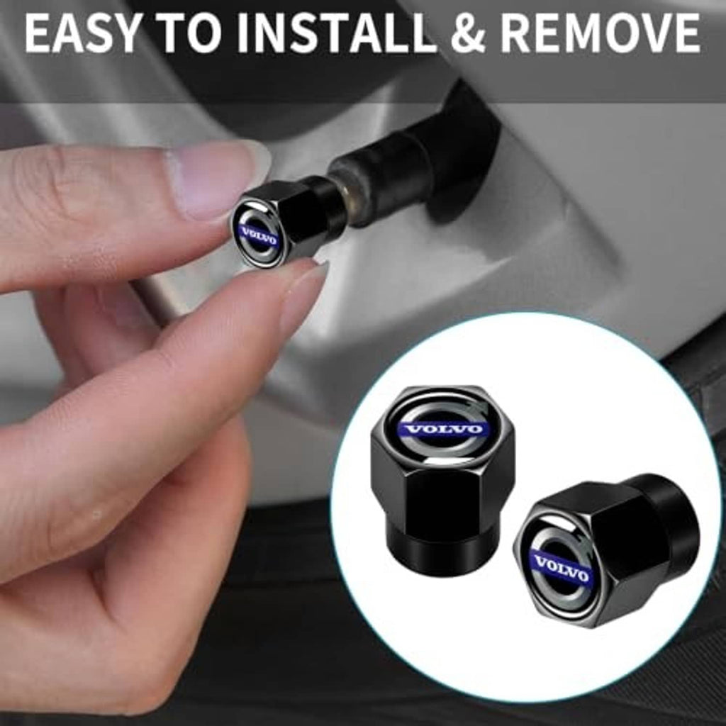 Hand installing a black hex tire valve stem cap with blue Volvo logo