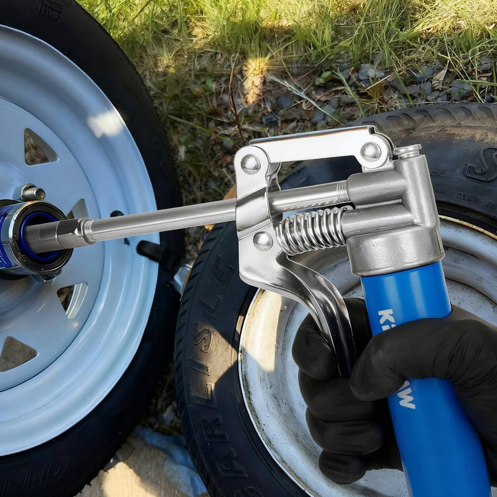 Blue grease gun used on wheel hub with chrome nozzle and black gloves