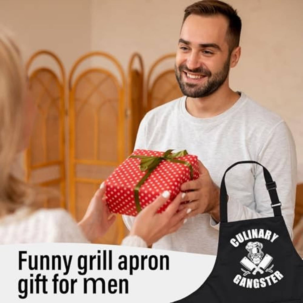 Black cooking apron worn by person holding a gift, 'Culinary Gangster' logo and chest bib